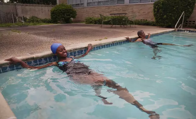 Sister Seyram Mary Adzokpa and Sister Clara Mae Jackson, of the Sisters of the Holy Family, swim in the pool at the motherhouse in New Orleans, Tuesday, June 25, 2024. (AP Photo/Jessie Wardarski)