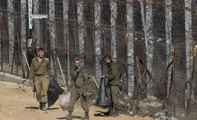 Israeli soldiers clean along the so-called Alpha Line that separates the Israeli-controlled Golan Heights from Syria, in the town of Majdal Shams, Tuesday, Dec. 17, 2024. (AP Photo/Matias Delacroix)