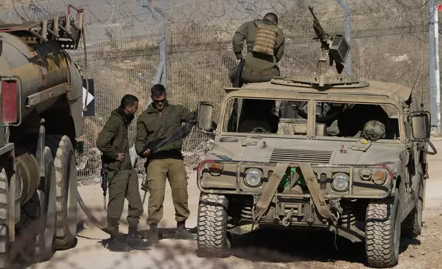 Israeli soldiers stand next to armoured vehicles after crossing the security fence, near the so-called Alpha Line that separates the Israeli-controlled Golan Heights from Syria, in the town of Majdal Shams, Tuesday, Dec. 17, 2024. (AP Photo/Matias Delacroix)