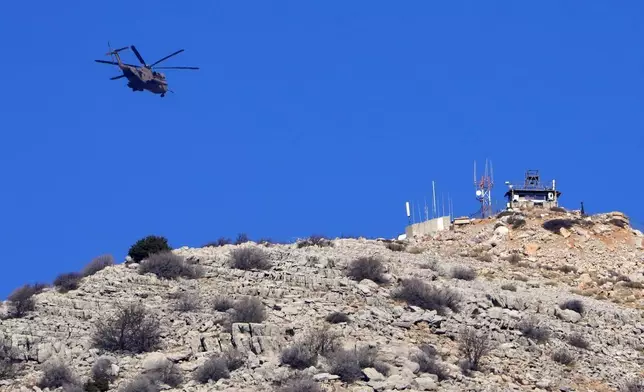 An Israeli Air Force Black Hawk helicopter flies over Mount Hermon, near the so-called Alpha Line that separates the Israeli-controlled Golan Heights from Syria, viewed from the town of Majdal Shams, Tuesday, Dec. 17, 2024. (AP Photo/Matias Delacroix)