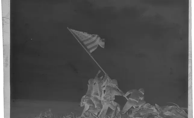 FILE - This is a full frame scan of the 4x5 negative of Joe Rosenthal's iconic Iwo Jima flag-raising photo from Feb. 23, 1945 and seen Oct. 24, 2017 in the Associated Press Photo Library in New York City. (AP Photo, File)