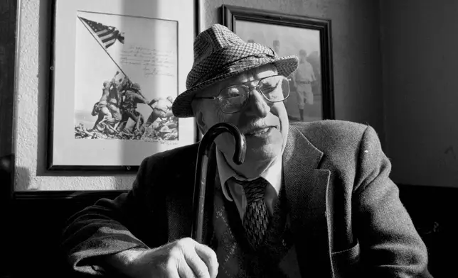 FILE- Joe Rosenthal, who took the iconic Iwo Jima flag raising photo in World War II, poses at the New Pisa Bar and restaurant in San Francisco, Dec. 20, 1994. (AP Photo/Eric Risberg, File)