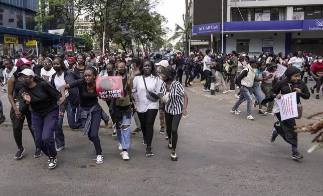 Demonstrators run from a cloud of tear gas fired by anti riot police during the march against the rising cases of femicide, in downtown Nairobi, Kenya, Tuesday, Dec. 10, 2024. (AP Photo/Brian Inganga)