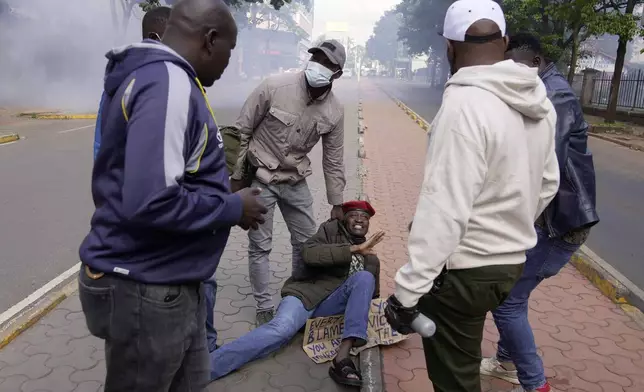 Kenya anti-riot police arrest a protester during the march against the rising cases of femicide, in downtown Nairobi, Kenya, Tuesday, Dec. 10, 2024. (AP Photo/Brian Inganga)