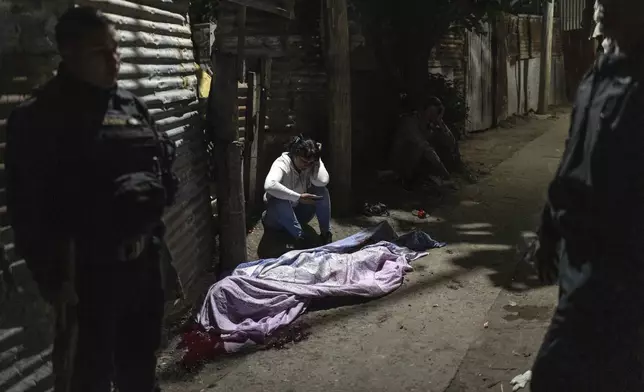 Relatives grieve over the body of 21-year-old Silvano Caballero, who was shot dead in the Villa Banana neighborhood of Rosario, Argentina, early Wednesday, Nov. 13, 2024. (AP Photo/Rodrigo Abd)