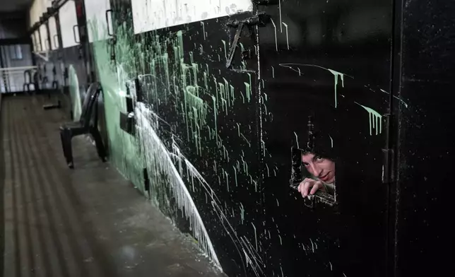 A prisoner peers from his cell as penitentiary agents search the pavilion where the most dangerous gang members are held at the Pinero prison, Rosario, Argentina, Saturday, Sept. 28, 2024. (AP Photo/Rodrigo Abd)