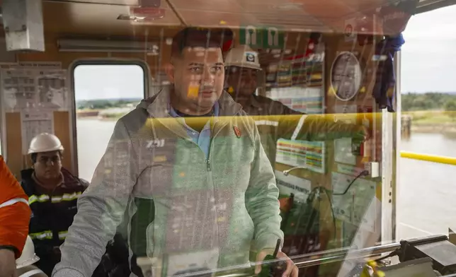 The captain of a cargo ship from the Paraguayan company Paranave works with his crew as they navigate the Paraguay River after leaving the port of Villeta on the outskirts of Asuncion, Paraguay, Thursday, July 11, 2024. (AP Photo/Rodrigo Abd)
