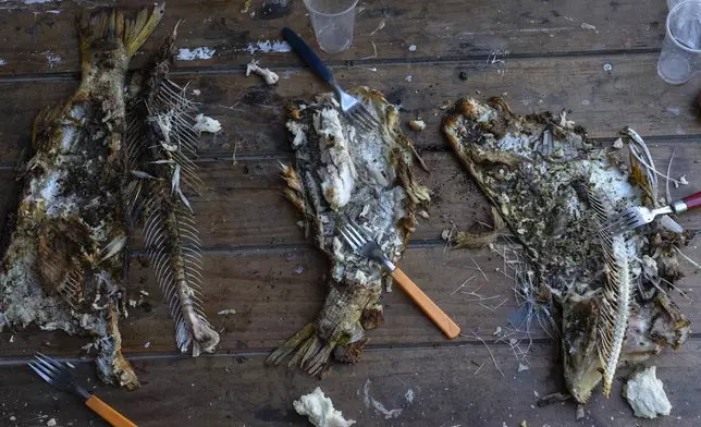 The bones of fish caught in the Parana River lay on the table after being eaten for lunch in Villa Gobernador Galvez, Argentina, Wednesday, Dec. 11, 2024. (AP Photo/Rodrigo Abd)