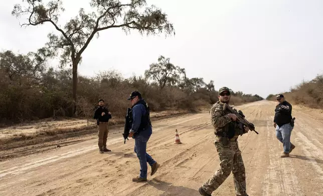 Agents from Paraguay's National Anti Drug Secretary (SENAD) stand guard at a check point in Filadelfia, the western region of Paraguay known as the Paraguayan Chaco, Tuesday, Aug. 27, 2024. (AP Photo/Rodrigo Abd)