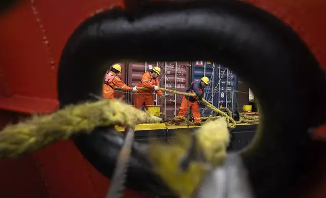 A crew works to release their cargo ship as they leave the port of Villeta, on the outskirts of Asuncion, Paraguay, Thursday, July 11, 2024. (AP Photo/Rodrigo Abd)