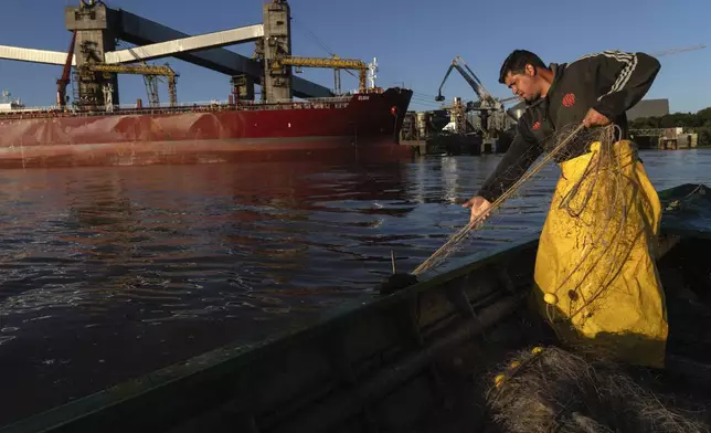 Dante Andino fishes in the Parana River in Villa Gobernador Galvez, Argentina, Tuesday, Dec. 10, 2024. (AP Photo/Rodrigo Abd)