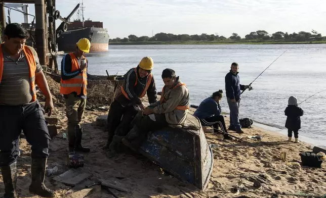Caacupemi port workers take a break on the Paraguay River in Asuncion, Paraguay, Tuesday, July 9, 2024. (AP Photo/Rodrigo Abd)