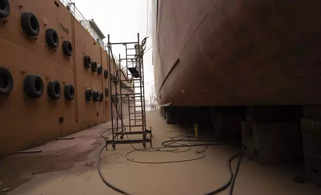 A worker repairs a wall on a ship at La Barca del Pescador shipyard on the banks of the Paraguay River in the port of Villeta on the outskirts of Asuncion, Paraguay, Thursday, July 11, 2024. (AP Photo/Rodrigo Abd)