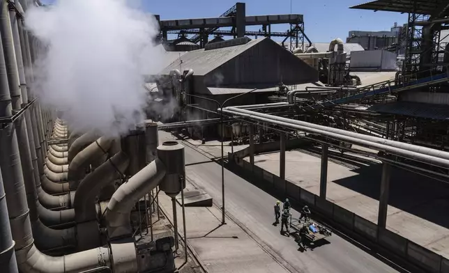 Workers walk at the Molinos Agro on the banks of the Parana River in San Lorenzo, Argentina, Tuesday, Dec. 3, 2024. (AP Photo/Rodrigo Abd)