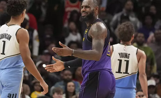 Los Angeles Lakers forward LeBron James (23) reacts to a foul against Atlanta Hawks guard Trae Young (11) in the second half of an NBA basketball game, Friday, Dec. 6, 2024, in Atlanta. (AP Photo/Brynn Anderson)