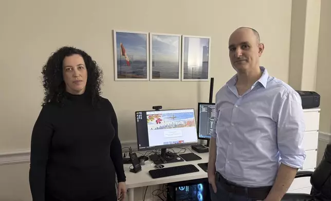 Michal Harel and her husband Avital Epstein show the website they set up to help Israelis navigate a move to Canada in Oakville, Ontario, Canada, Wednesday, Dec. 4, 2024. (AP Photo/Rob Gillies)