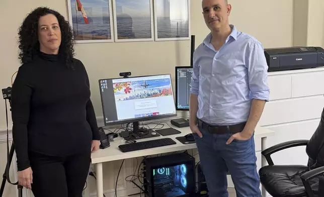 Michal Harel and her husband Avital Epstein show the website they set up to help Israelis navigate a move to Canada in Oakville, Ontario, Canada, Wednesday, Dec. 4, 2024. (AP Photo/Rob Gillies)