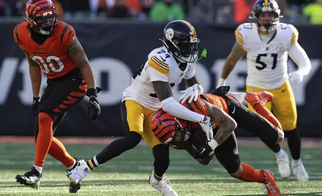 Pittsburgh Steelers cornerback Joey Porter Jr. (24) tackles Cincinnati Bengals running back Chase Brown, center bottom, during the first half of an NFL football game Sunday, Dec. 1, 2024, in Cincinnati. (AP Photo/Jeff Dean)