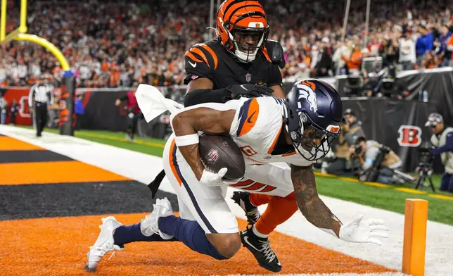 Denver Broncos wide receiver Courtland Sutton (14) makes a catch for a touchdown in front of Cincinnati Bengals cornerback Josh Newton (28) during the second half of an NFL football game in Cincinnati, Saturday, Dec. 28, 2024. (AP Photo/Jeff Dean)