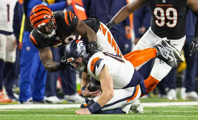 Cincinnati Bengals defensive end Cedric Johnson (52) sacks Denver Broncos quarterback Bo Nix (10) during the first half of an NFL football game in Cincinnati, Saturday, Dec. 28, 2024. (AP Photo/Jeff Dean)