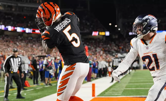 Cincinnati Bengals wide receiver Tee Higgins (5) makes a catch for a touchdown in front of Denver Broncos cornerback Riley Moss (21) during the second half of an NFL football game in Cincinnati, Saturday, Dec. 28, 2024. (AP Photo/Jeff Dean)