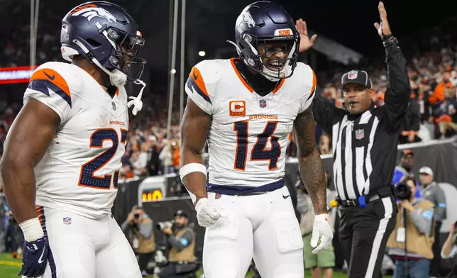 Denver Broncos wide receiver Courtland Sutton (14) celebrates a touchdown with running back Audric Estime (23) against the Cincinnati Bengals during the second half of an NFL football game in Cincinnati, Saturday, Dec. 28, 2024. (AP Photo/Jeff Dean)