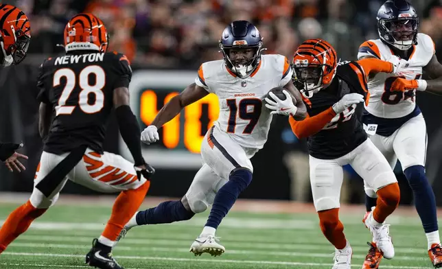 Denver Broncos wide receiver Marvin Mims Jr. (19) cuts in from top Cincinnati Bengals cornerback Josh Newton (28) during the second half of an NFL football game in Cincinnati, Saturday, Dec. 28, 2024. (AP Photo/Carolyn Kaster)