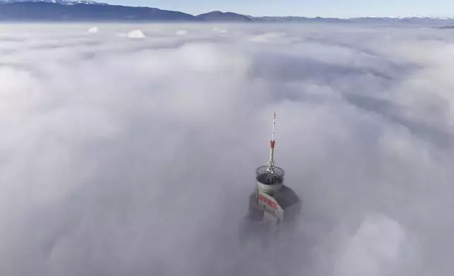 Avaz Twist Tower building, 172 meters high, peaks through a dense layer of fog and smog in Sarajevo, Bosnia, Thursday, Dec. 19, 2024. (AP Photo/Armin Durgut)