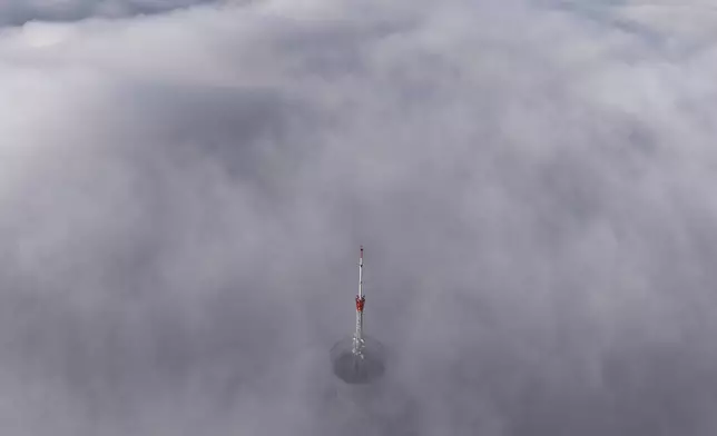 Avaz Twist Tower building, 172 meters high, peaks through a dense layer of fog and smog in Sarajevo, Bosnia, Thursday, Dec. 19, 2024. (AP Photo/Armin Durgut)