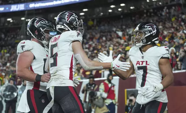 Atlanta Falcons running back Bijan Robinson (7) celebrates his touchdown with wide receiver Drake London (5) during the first half of an NFL football game against the Washington Commanders, Sunday, Dec. 29, 2024, in Landover. (AP Photo/Stephanie Scarbrough)