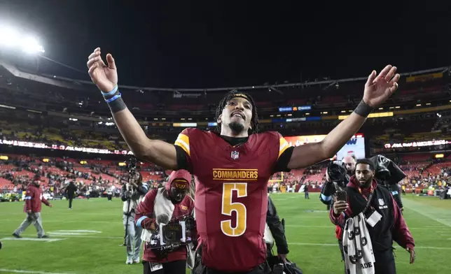 Washington Commanders quarterback Jayden Daniels (5) celebrates after winning over the Atlanta Falcons in overtime during an NFL football game, Sunday, Dec. 29, 2024, in Landover, Md. The Commanders won 30-24. (AP Photo/Nick Wass)