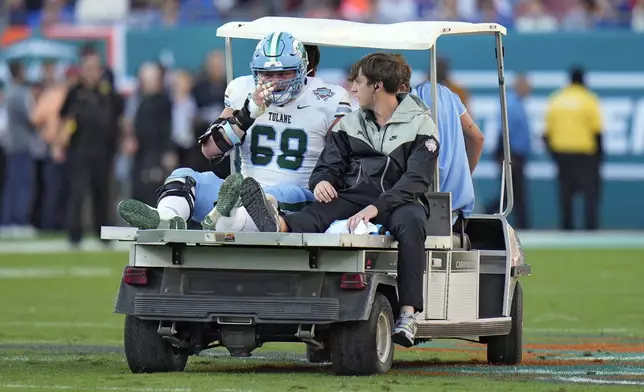 Tulane offensive lineman Josh Remetich (68) is carted off the field after getting injured during the first half of the Gasparilla Bowl NCAA college football game against Florida Friday, Dec. 20, 2024, in Tampa, Fla. (AP Photo/Chris O'Meara)