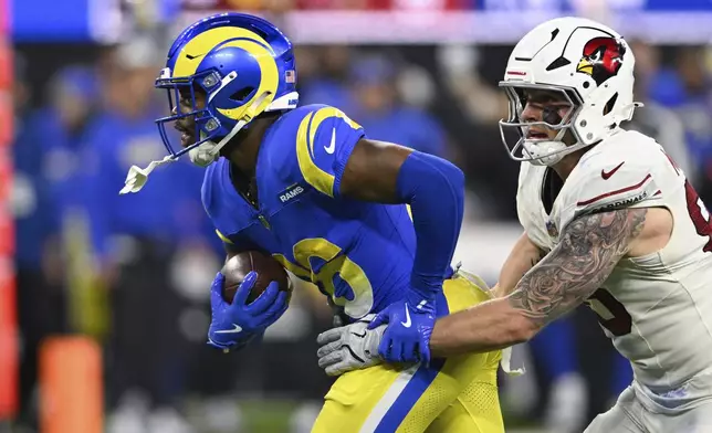 Los Angeles Rams safety Kamren Kinchens, left, intercepts a pass intended for Arizona Cardinals tight end Trey McBride, left, during the second half of an NFL football game Saturday, Dec. 28, 2024, in Inglewood, Calif. (AP Photo/Alex Gallardo)