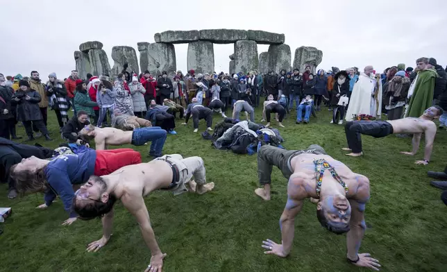 People tale part in the winter Solstice celebrations at Stonehenge, England, Saturday, Dec. 21, 2024. (AP Photo/Anthony Upton)