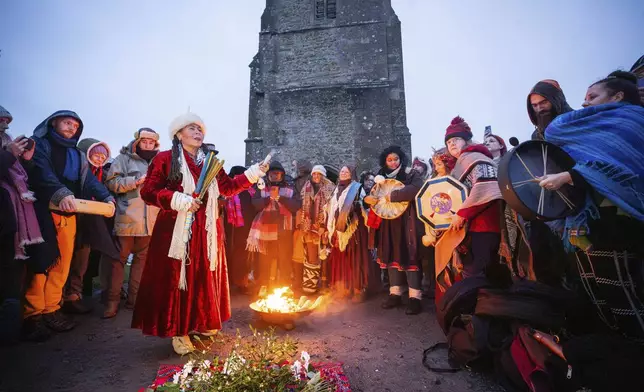 People take part in the winter solstice celebrations during sunrise at Glastonbury Tor in Somerset, England, Saturday Dec. 21, 2024. (James Manning/PA via AP)