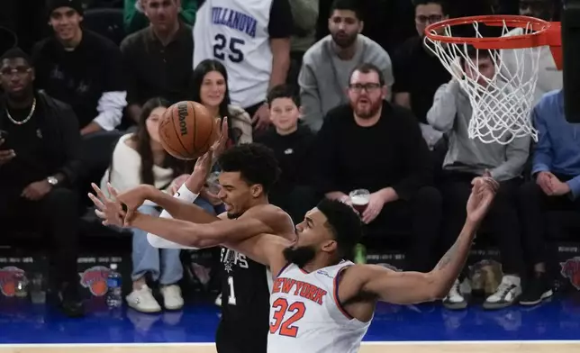 San Antonio Spurs' Victor Wembanyama, left, and New York Knicks' Karl-Anthony Towns fight for a rebound during the second half of an NBA basketball game, Wednesday, Dec. 25, 2024, in New York. The Knicks defeated the Spurs 117-114. (AP Photo/Seth Wenig)