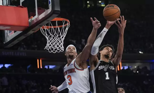 New York Knicks' Josh Hart (3), left, and San Antonio Spurs' Victor Wembanyama fight for a rebound during the second half of an NBA basketball game, Wednesday, Dec. 25, 2024, in New York. The Knicks defeated the Spurs 117-114. (AP Photo/Seth Wenig)