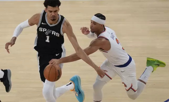 New York Knicks' Josh Hart, right, tries to grab the ball from San Antonio Spurs' Victor Wembanyama during the second half of an NBA basketball game, Wednesday, Dec. 25, 2024, in New York. The Knicks defeated the Spurs 117-114. (AP Photo/Seth Wenig)