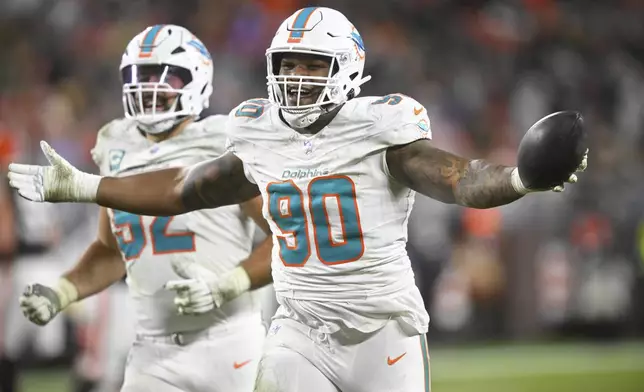 Miami Dolphins defensive tackle Da'Shawn Hand (90) reacts after recovering a Cleveland Browns fumble during the second half of an NFL football game Sunday, Dec. 29, 2024, in Cleveland. (AP Photo/David Richard)