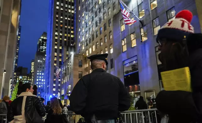 A New York police officer keep watch at Rockefeller Center before the start of the Rockefeller Center tree lighting ceremony, Wednesday, Dec. 4, 2024, in New York. (AP Photo/Julia Nikhinson)