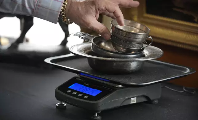 Silverware is weighed during an appraisal at Thomaston Place Auction Galleries, Tuesday, Nov. 19, 2024, in Thomaston, Maine. (AP Photo/Robert F. Bukaty)