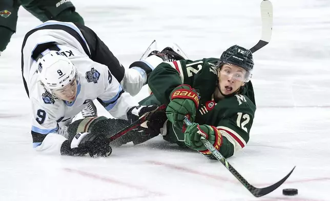 Minnesota Wild left wing Matt Boldy, right, reaches for the puck as Utah Hockey Club center Clayton Keller defends during the first period of an NHL hockey game Friday, Dec. 20, 2024, in St. Paul, Minn. (AP Photo/Matt Krohn)