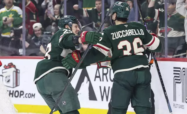 Minnesota Wild right wing Mats Zuccarello, right, celebrates his goal with center Marco Rossi during the first period of an NHL hockey game against the Utah Hockey Club Friday, Dec. 20, 2024, in St. Paul, Minn. (AP Photo/Matt Krohn)