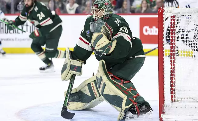 Minnesota Wild goaltender Marc-Andre Fleury, foreground, defends his net against the Utah Hockey Club during the second period of an NHL hockey game Friday, Dec. 20, 2024, in St. Paul, Minn. (AP Photo/Matt Krohn)