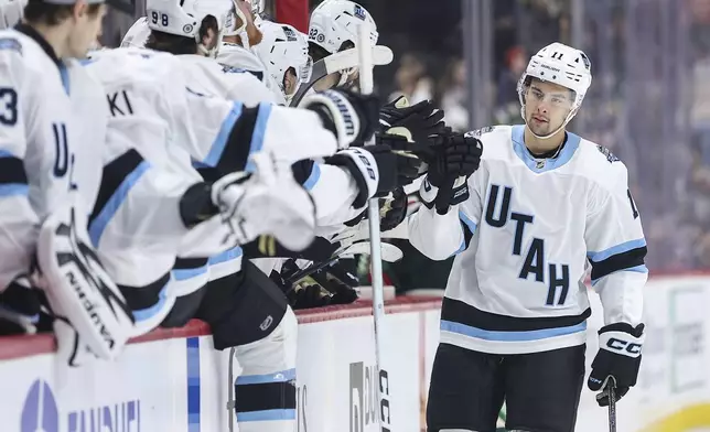 Utah Hockey Club right wing Dylan Guenther (11) is congratulated for his goal against the Minnesota Wild during the first period of an NHL hockey game Friday, Dec. 20, 2024, in St. Paul, Minn. (AP Photo/Matt Krohn)