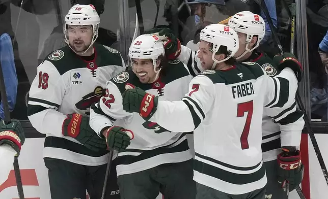 Minnesota Wild center Marat Khusnutdinov, center, celebrates with teammates after scoring against the Utah Hockey Club during the second period of an NHL hockey game Tuesday, Dec. 10, 2024, in Salt Lake City. (AP Photo/Rick Bowmer)