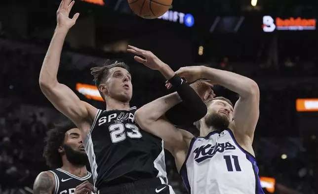 Sacramento Kings forward Domantas Sabonis (11) is fouled by San Antonio Spurs forward Zach Collins (23) during the first half of an NBA basketball game in San Antonio, Friday, Dec. 6, 2024. (AP Photo/Eric Gay)