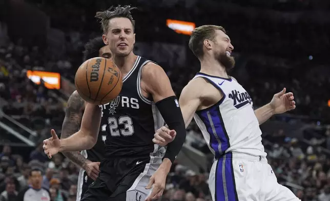 Sacramento Kings forward Domantas Sabonis, right, is fouled by San Antonio Spurs forward Zach Collins (23) during the first half of an NBA basketball game in San Antonio, Friday, Dec. 6, 2024. (AP Photo/Eric Gay)