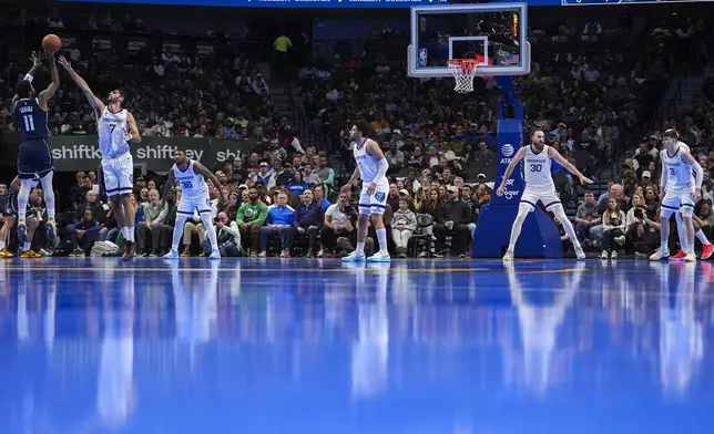 Dallas Mavericks guard Kyrie Irving (11) shoots against Memphis Grizzlies forward Santi Aldama (7) during the first half of an Emirates NBA Cup basketball game, Tuesday, Dec. 3, 2024, in Dallas. (AP Photo/Julio Cortez)