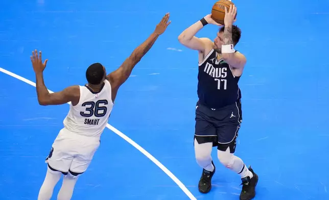 Dallas Mavericks guard Luka Doncic (77) shoots against Memphis Grizzlies guard Marcus Smart (36) during the second half of an Emirates NBA Cup basketball game, Tuesday, Dec. 3, 2024, in Dallas. The Mavericks won 121-116. (AP Photo/Julio Cortez)